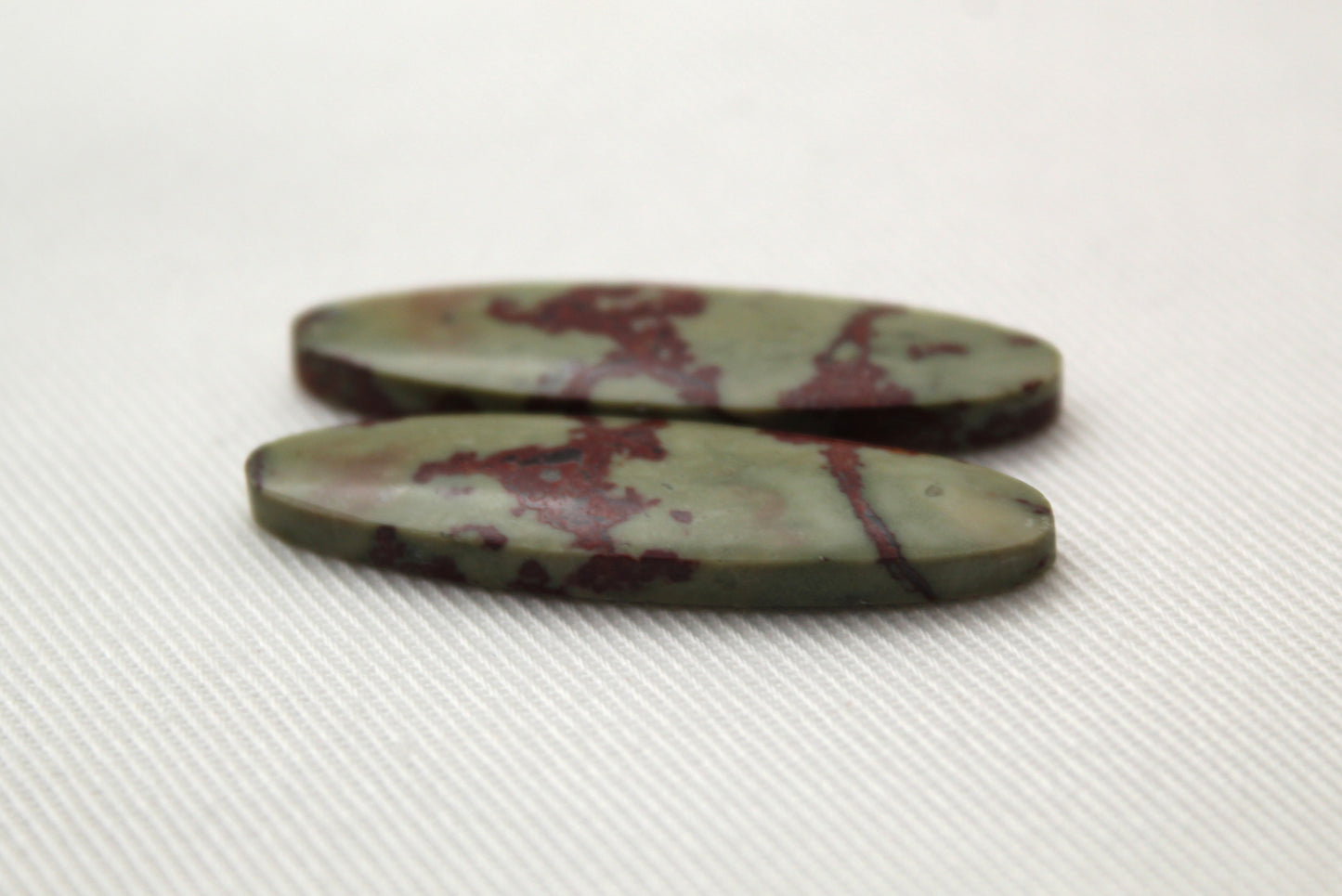 Matching pair of Red Fiber Jasper Cabochons oval green