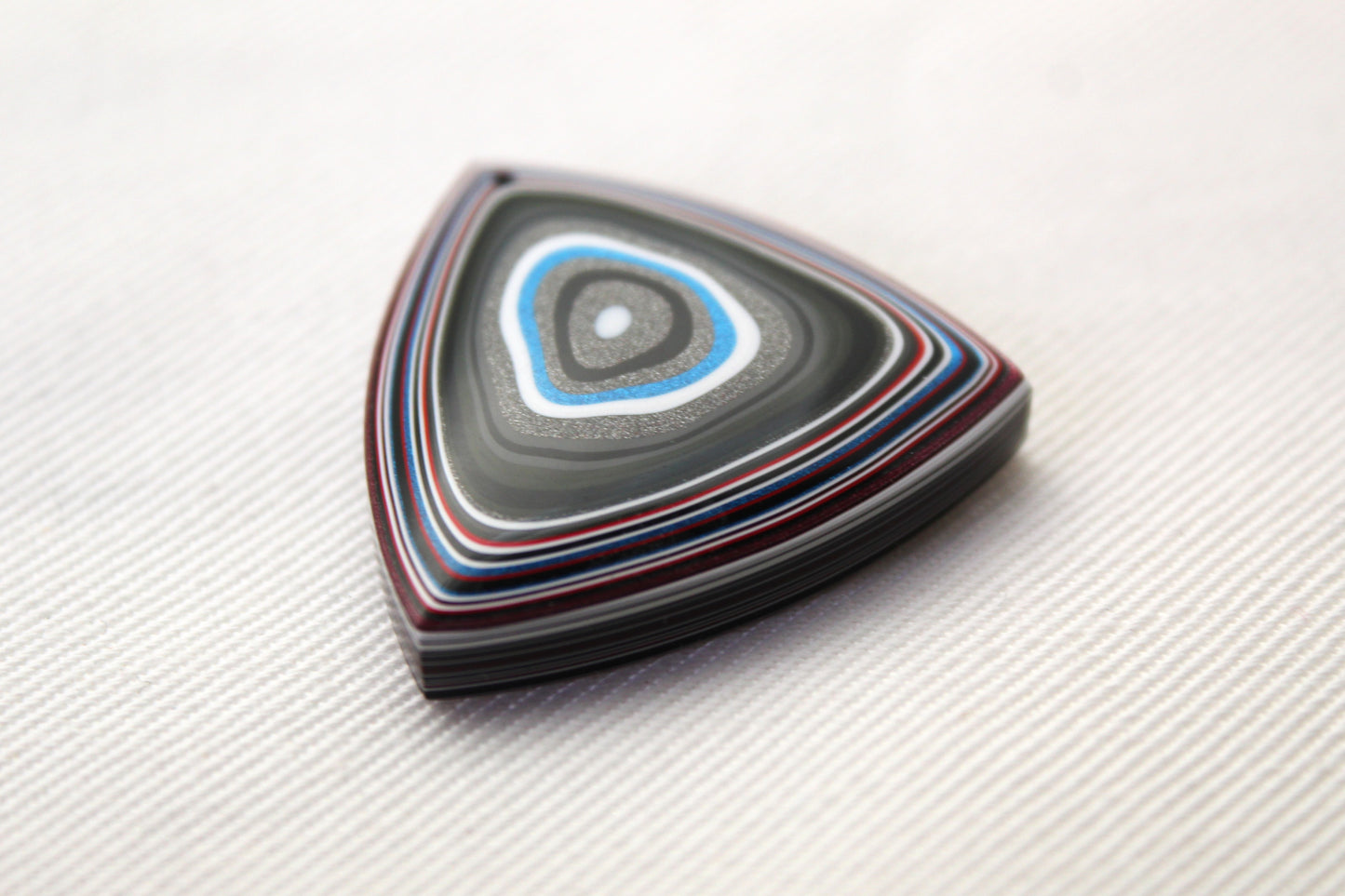 <tc>Cabochon de Fordite blanc rouge noir bleu trillion</tc>